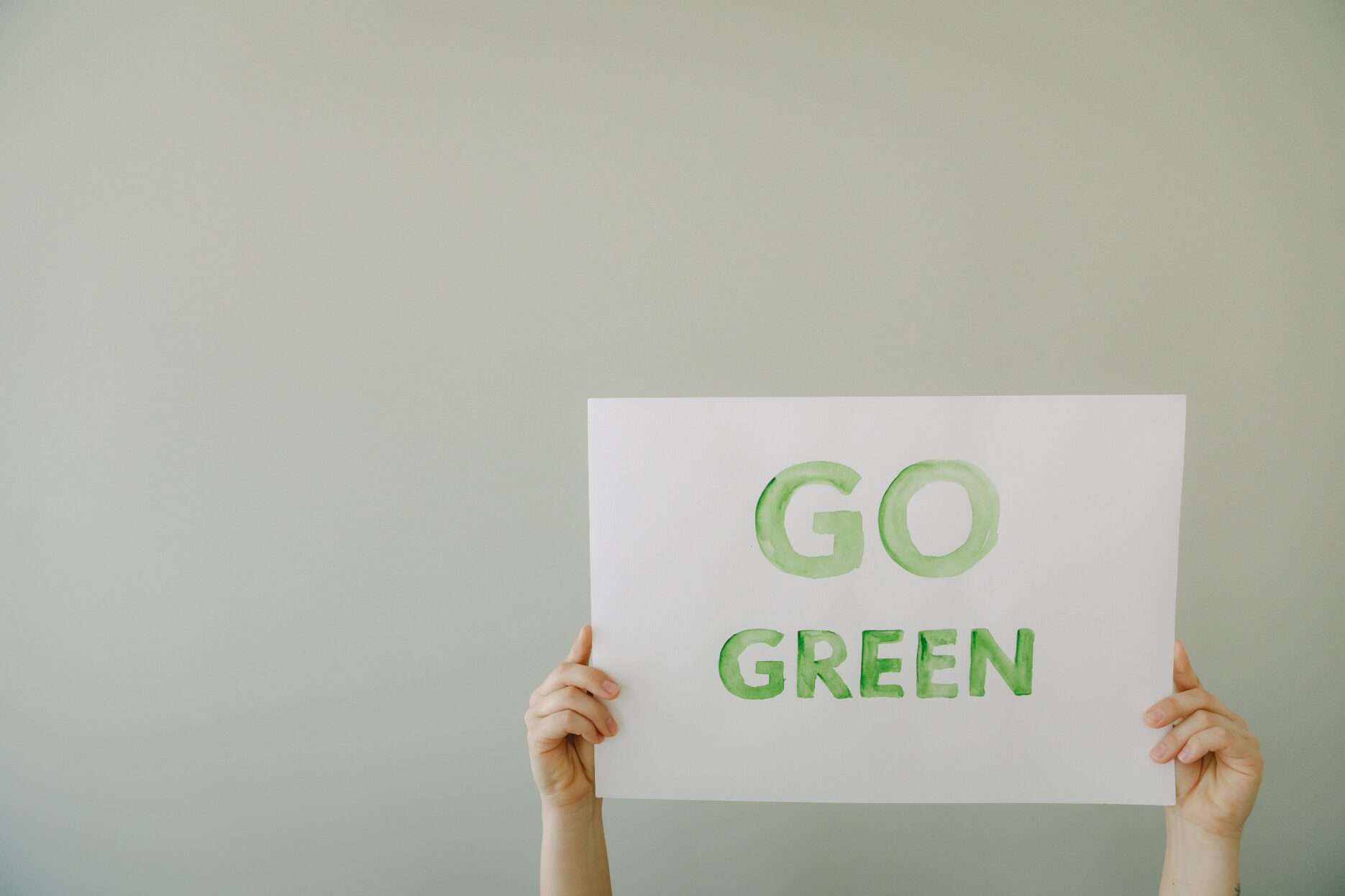 ręce trzymające kartę z napisem "GO GREEN"