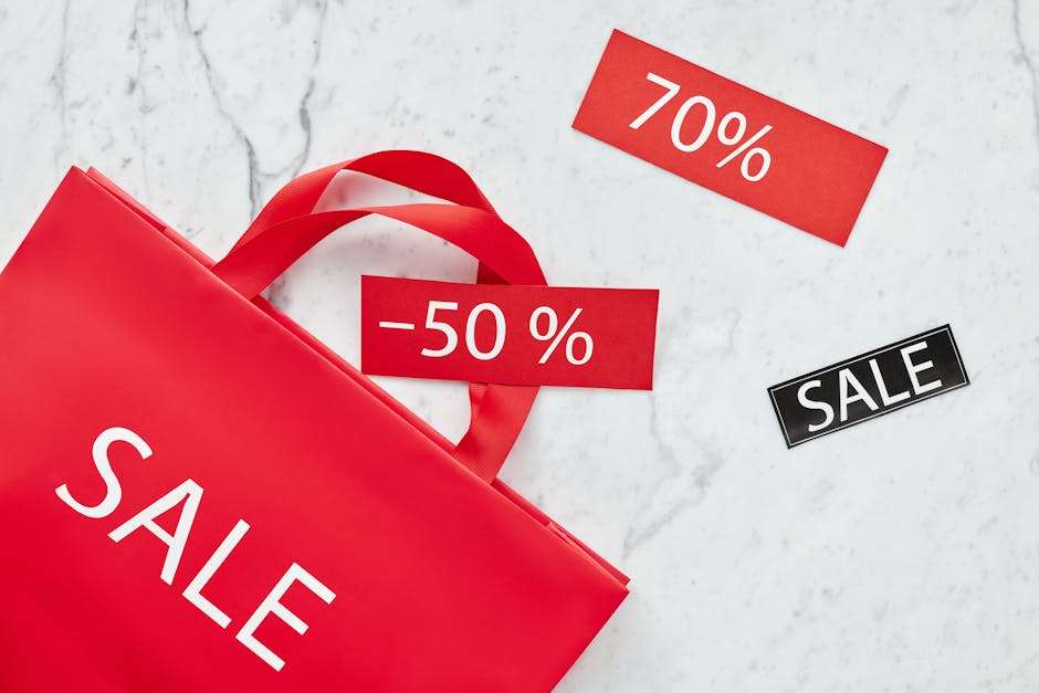 Czerwona torba zakupowa z napisami „SALE” oraz metkami z rabatami 70% i 50%.