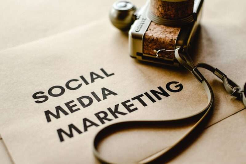 Vintage aparat fotograficzny z korkowymi detalami leżący na papierze z napisem Social Media Marketing.
