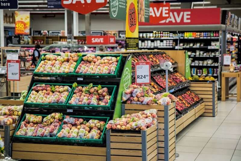 Świeże owoce z cenami w supermarkecie.