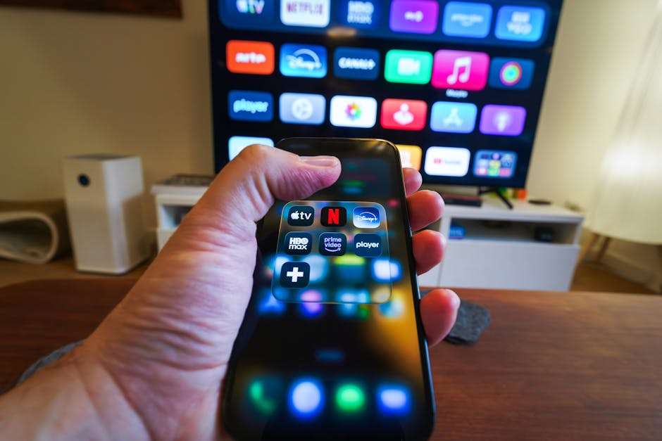 smartfon w ręku na tle telewizora